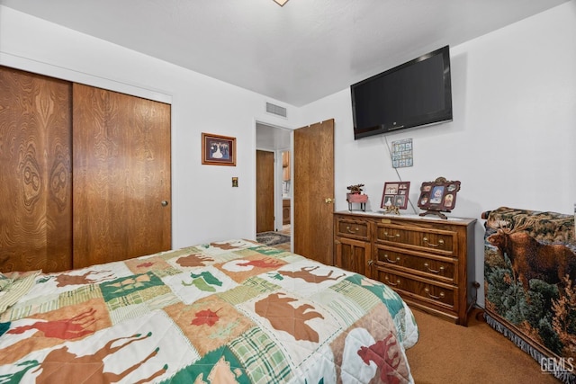 carpeted bedroom featuring visible vents and a closet