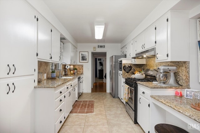 kitchen featuring tasteful backsplash, under cabinet range hood, appliances with stainless steel finishes, white cabinetry, and visible vents