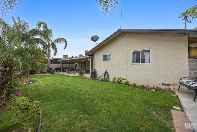 exterior space featuring crawl space, fence, a yard, a patio, and stucco siding