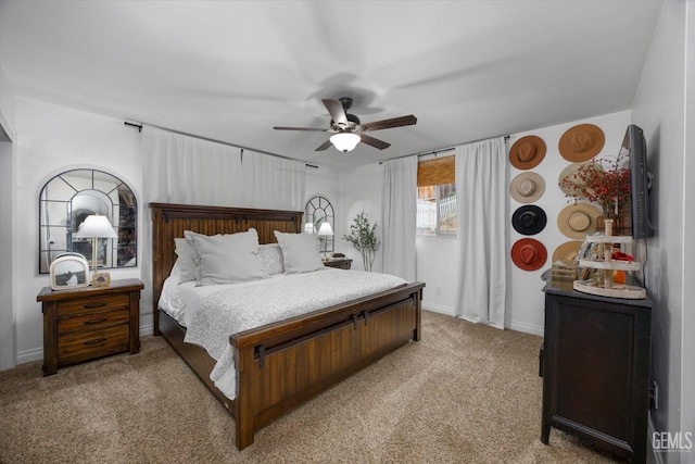 bedroom with ceiling fan, baseboards, and light carpet