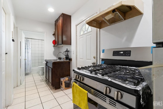 kitchen featuring sink, dark brown cabinets, extractor fan, stainless steel gas range oven, and light tile patterned flooring