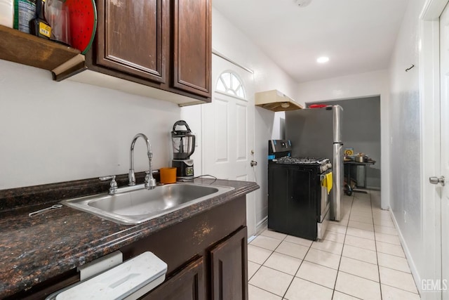 kitchen with dark brown cabinetry, black range with gas cooktop, sink, and light tile patterned floors