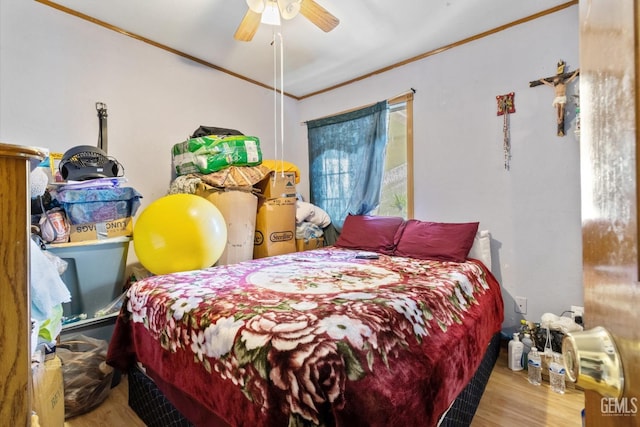 bedroom featuring hardwood / wood-style floors, ornamental molding, and ceiling fan