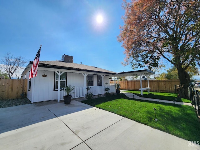 view of front facade with a porch, a front yard, and fence