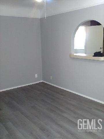 1403 Shasta St, Bakersfield, CA 93308 - empty room with arched walkways and dark wood-style floors