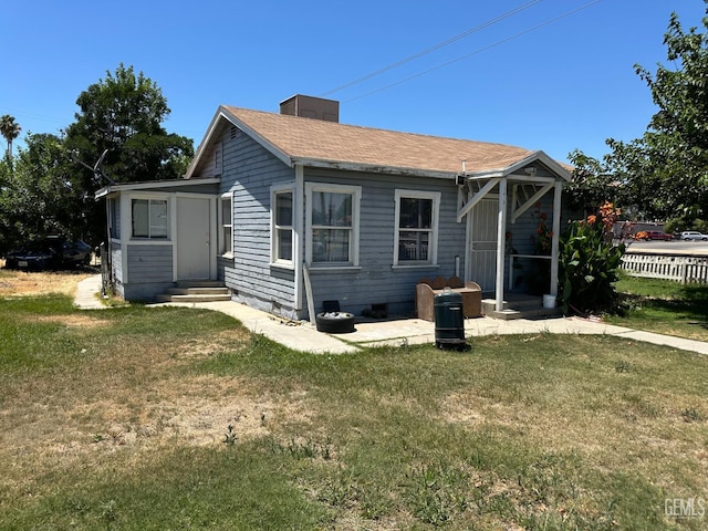 1403 Shasta St, Bakersfield, CA 93308 - rear view of house with a lawn, entry steps, and a chimney