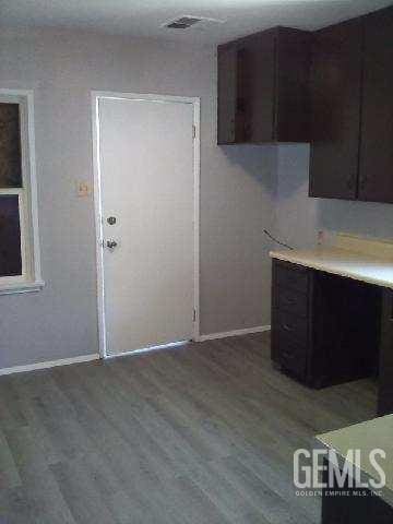 1403 Shasta St, Bakersfield, CA 93308 - kitchen featuring wood finished floors, light countertops, and dark brown cabinetry