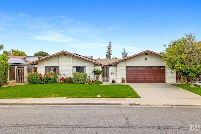 3406 Elm St, Bakersfield, CA 93301 - ranch-style house with a front lawn, driveway, fence, a garage, and brick siding