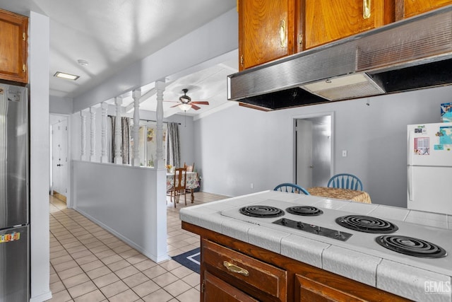 3406 Elm St, Bakersfield, CA 93301 - kitchen with stove, freestanding refrigerator, under cabinet range hood, and light tile patterned floors