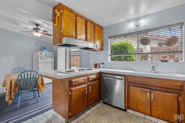 3406 Elm St, Bakersfield, CA 93301 - kitchen featuring a sink, brown cabinetry, decorative backsplash, white appliances, and under cabinet range hood