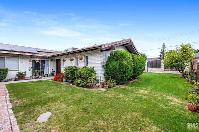 3406 Elm St, Bakersfield, CA 93301 - ranch-style home featuring roof mounted solar panels, fence, and a front lawn
