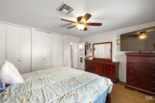 3406 Elm St, Bakersfield, CA 93301 - bedroom with carpet flooring, multiple closets, visible vents, and a textured ceiling