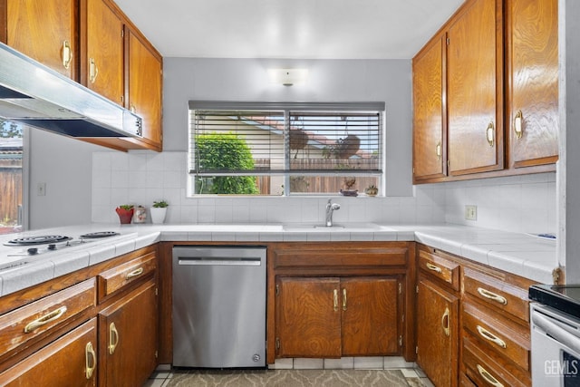 3406 Elm St, Bakersfield, CA 93301 - kitchen featuring brown cabinetry, decorative backsplash, appliances with stainless steel finishes, and under cabinet range hood