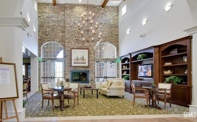 living room with french doors, a towering ceiling, and an inviting chandelier