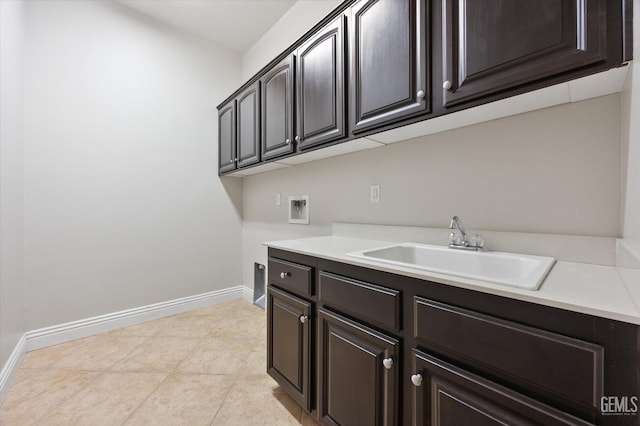 laundry area with cabinets, sink, light tile patterned floors, and hookup for a washing machine