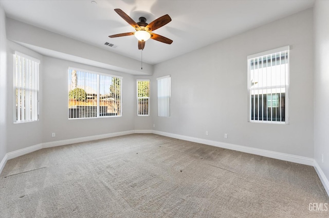 empty room with ceiling fan, carpet flooring, and a healthy amount of sunlight