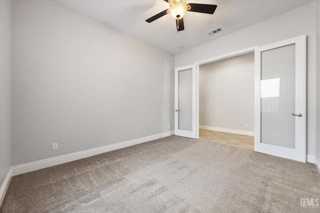 unfurnished bedroom with ceiling fan, light carpet, and french doors