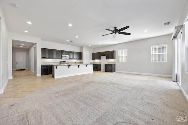 unfurnished living room featuring ceiling fan and light tile patterned floors