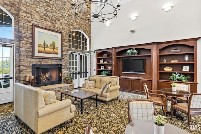 living room featuring a fireplace, an inviting chandelier, and a towering ceiling