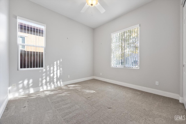 carpeted spare room featuring ceiling fan