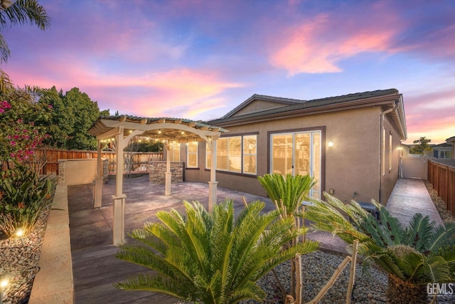 back house at dusk featuring a patio area