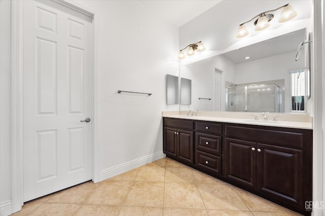 bathroom with a shower with door, vanity, and tile patterned flooring