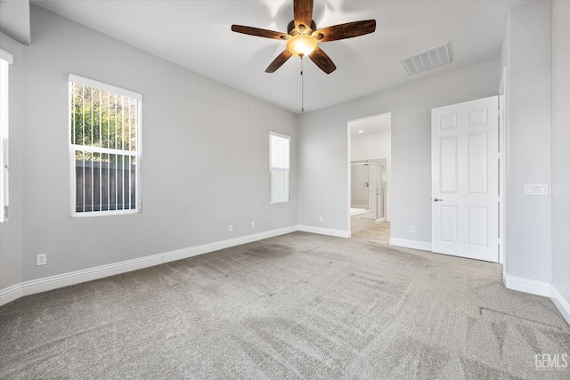 unfurnished bedroom with ceiling fan, light carpet, and connected bathroom