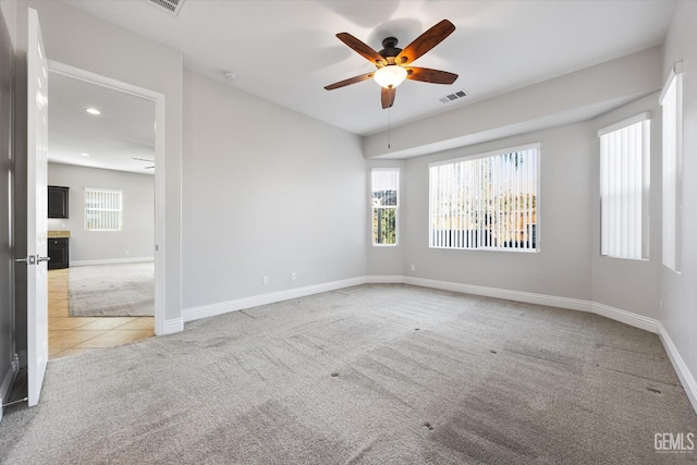 carpeted spare room featuring ceiling fan