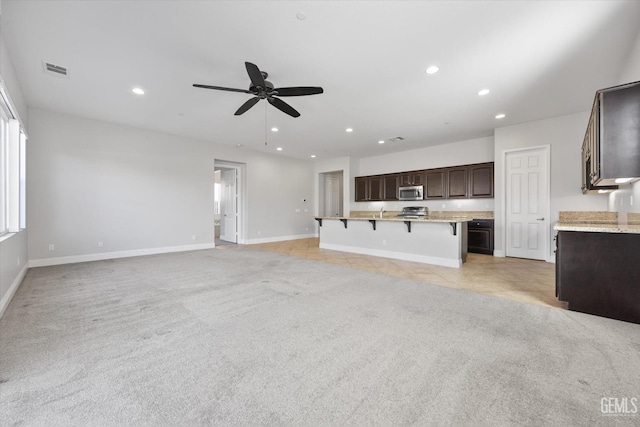 unfurnished living room with ceiling fan and light carpet