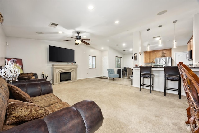 living room featuring ceiling fan, vaulted ceiling, and light carpet