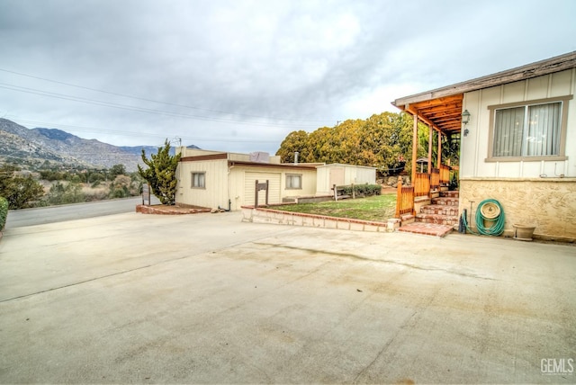 view of side of home with a patio and a mountain view