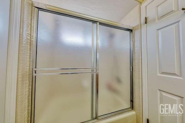 bathroom featuring combined bath / shower with glass door