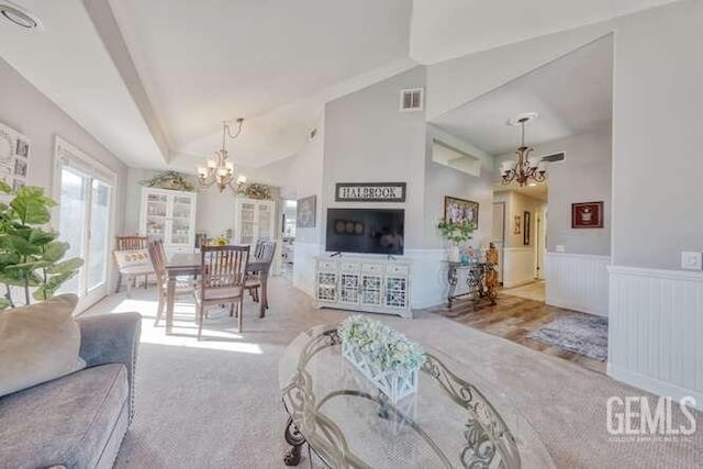 living room featuring vaulted ceiling and a notable chandelier