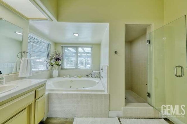 bathroom featuring plus walk in shower and vanity