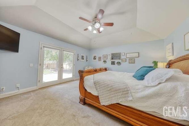 carpeted bedroom with ceiling fan, french doors, a tray ceiling, lofted ceiling, and access to outside