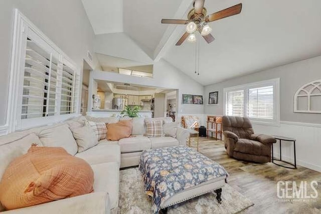 living room with light wood-type flooring, lofted ceiling with beams, and ceiling fan