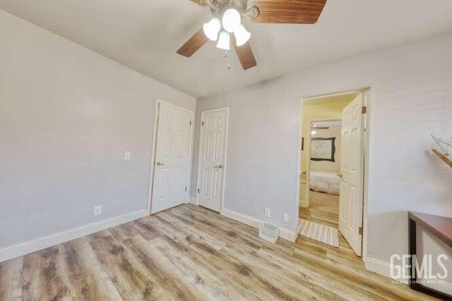 unfurnished bedroom featuring ensuite bath, ceiling fan, and light wood-type flooring