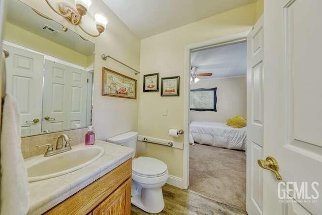 bathroom with ceiling fan, hardwood / wood-style floors, vanity, and toilet