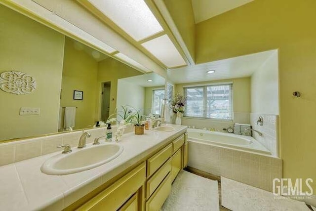 bathroom featuring tiled bath, tile patterned flooring, and vanity