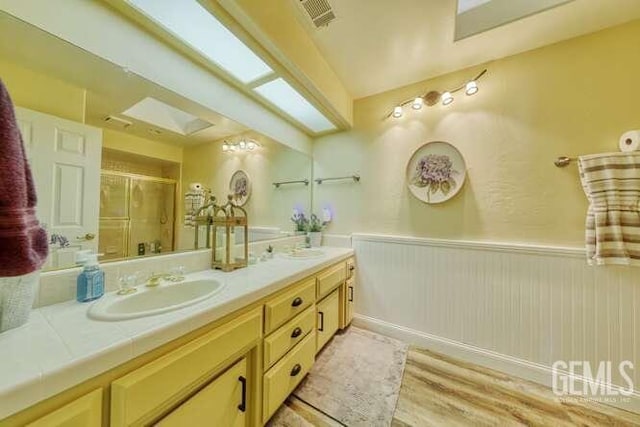 bathroom featuring vanity, wood-type flooring, and an enclosed shower