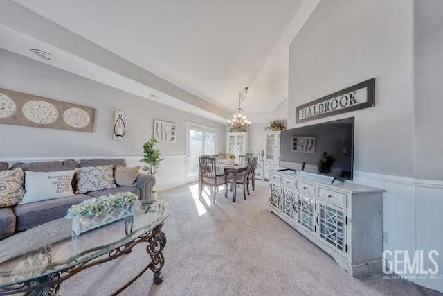 carpeted living room featuring a notable chandelier and lofted ceiling