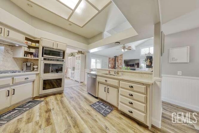 kitchen with cream cabinetry, ceiling fan, stainless steel appliances, and vaulted ceiling