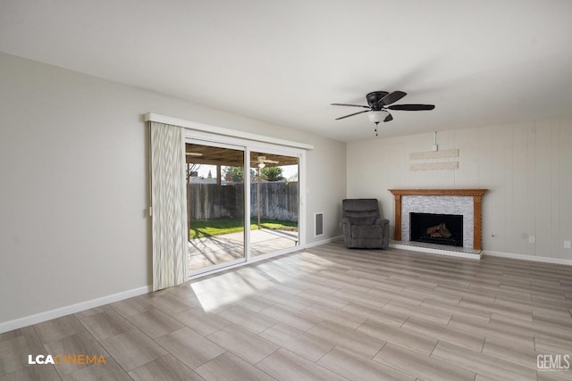 unfurnished living room featuring a ceiling fan, visible vents, a fireplace, and baseboards