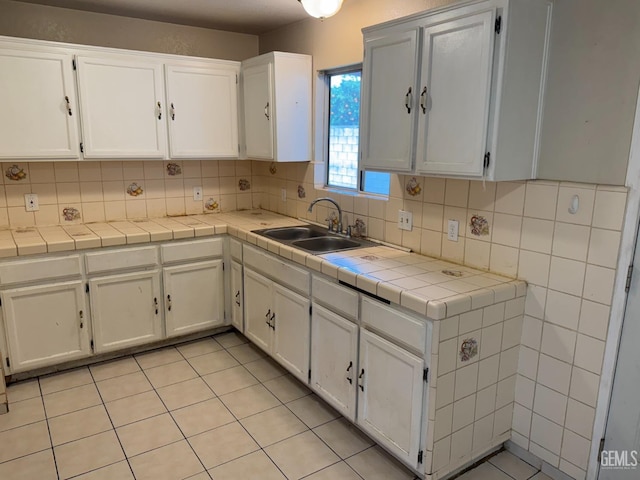 kitchen with tile countertops and white cabinets