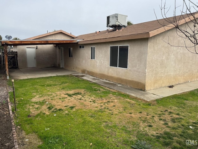 back of house featuring a yard, central AC unit, and a patio