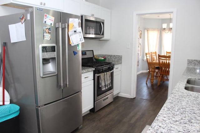 327 Ray St, Bakersfield, CA 93308 - kitchen featuring appliances with stainless steel finishes, dark wood-style flooring, white cabinets, a chandelier, and light stone counters
