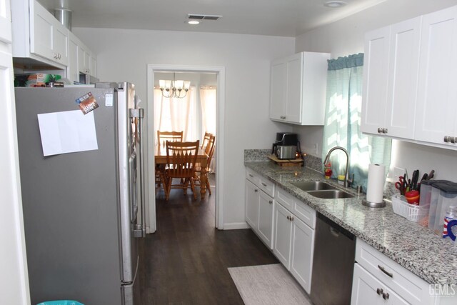 327 Ray St, Bakersfield, CA 93308 - kitchen featuring appliances with stainless steel finishes, healthy amount of natural light, and white cabinetry