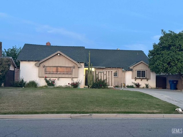 ranch-style house with a chimney, fence, a shingled roof, concrete driveway, and a front yard