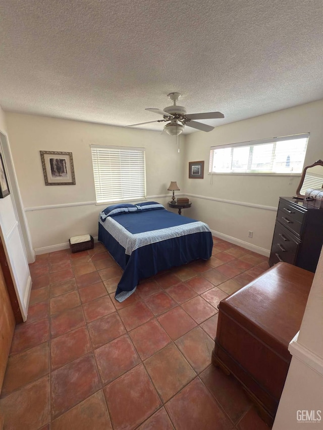 tiled bedroom featuring a textured ceiling and a ceiling fan
