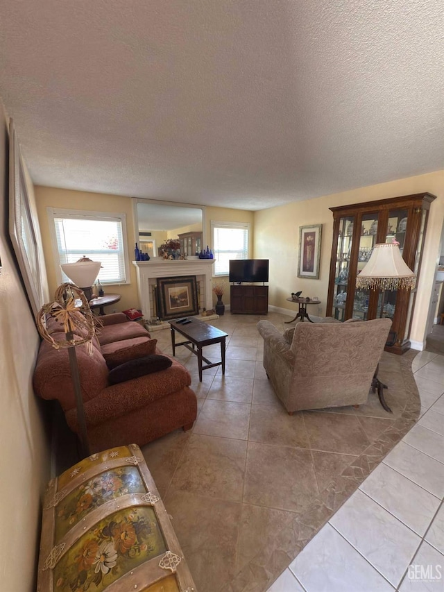 living area with tile patterned flooring, a textured ceiling, and a fireplace